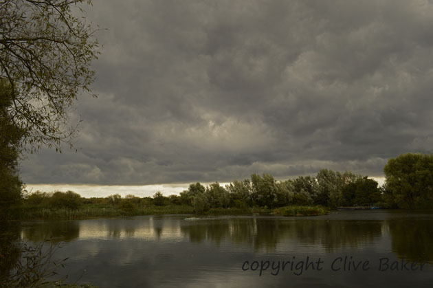 Cold front of cloud over small body of water.