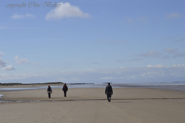 Three walkers on beach